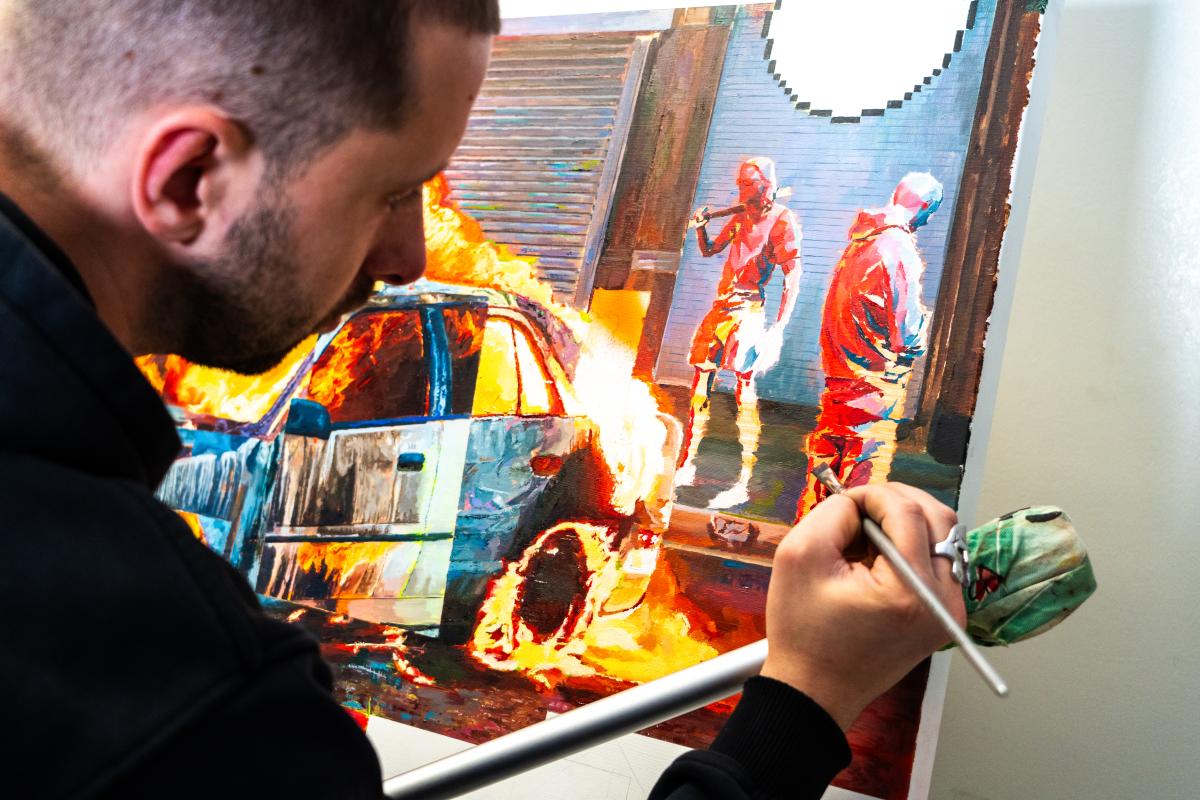 A man adding finishing touches to a painting